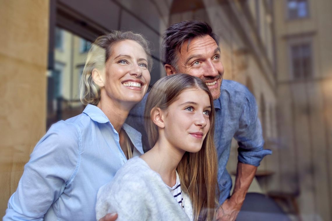 portret szczęśliwej rodziny za szybą